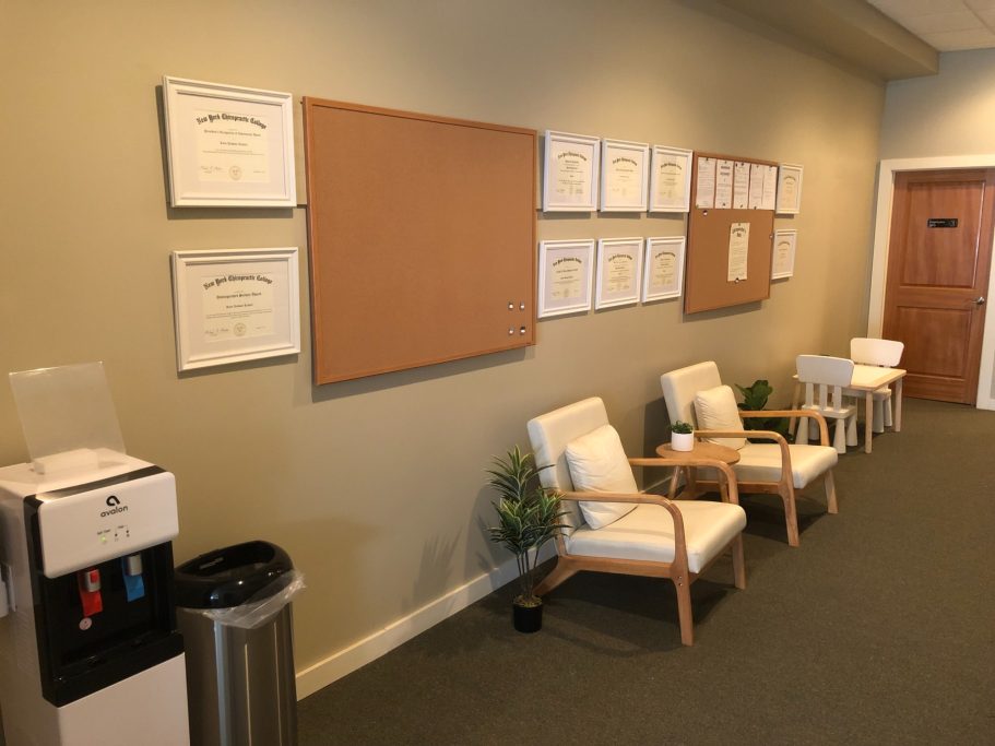 Family Waiting Space with Kids Play Table Image of waiting room hallway. There are two modern chairs, a water cooler, a silver garbage can, succulent décor and a children's table.